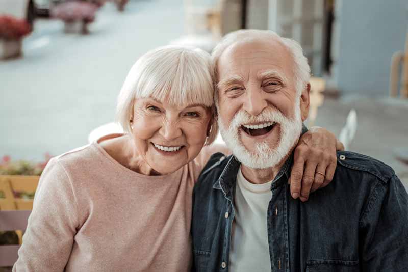a couple smiling with their new dental implants