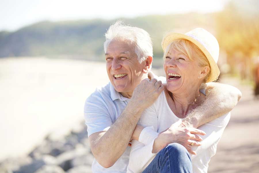 a couple smiling with their new dental implants