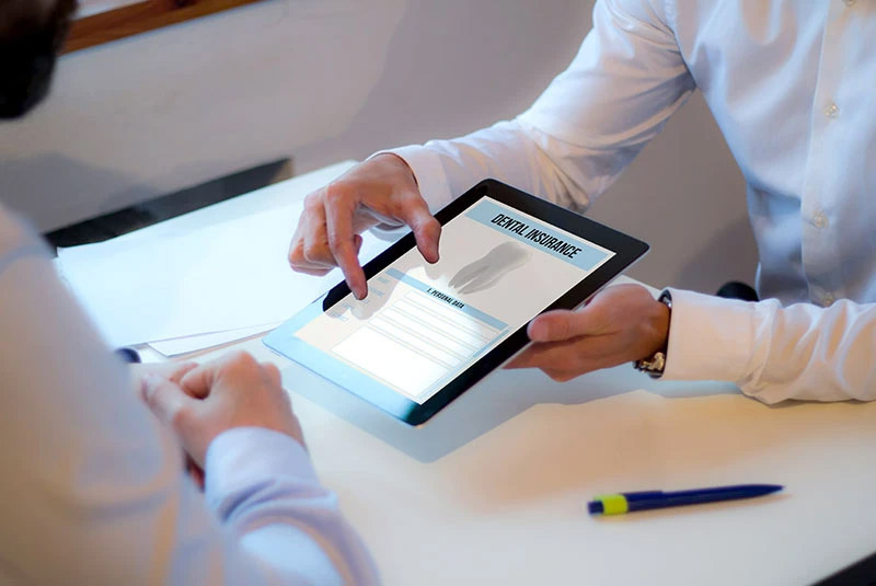 Dental Patient Being Shown A Tablet With Dental Insurance Options