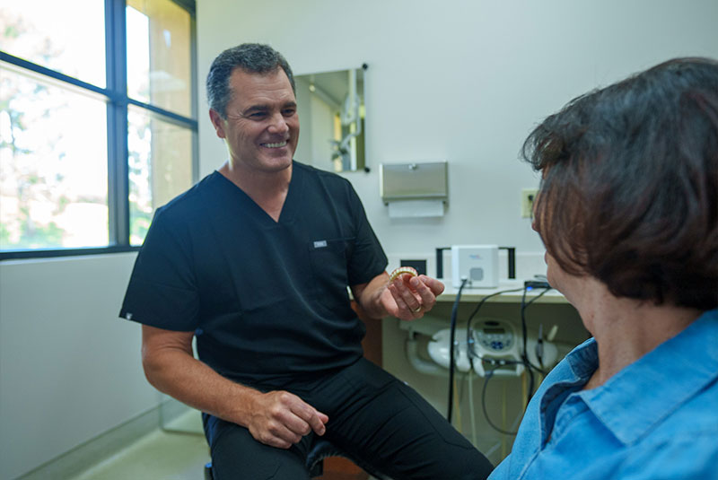 Dr clark Michael holding implant model to patient