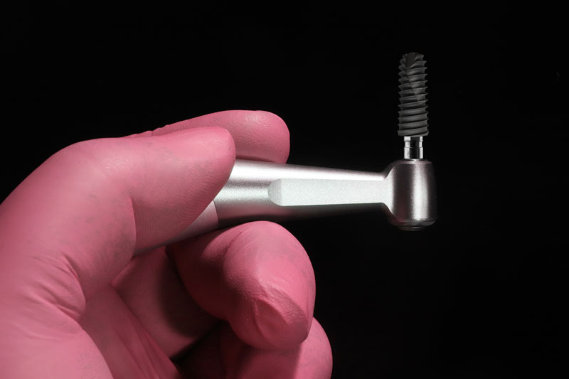 an implant being held up with a placement tool