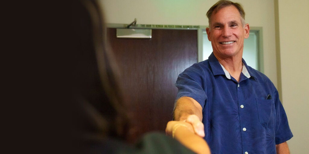 patient shaking hand of staff member