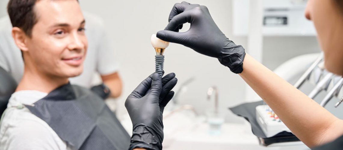 Aesthetic stomatology client watching at process of dental implant installation.