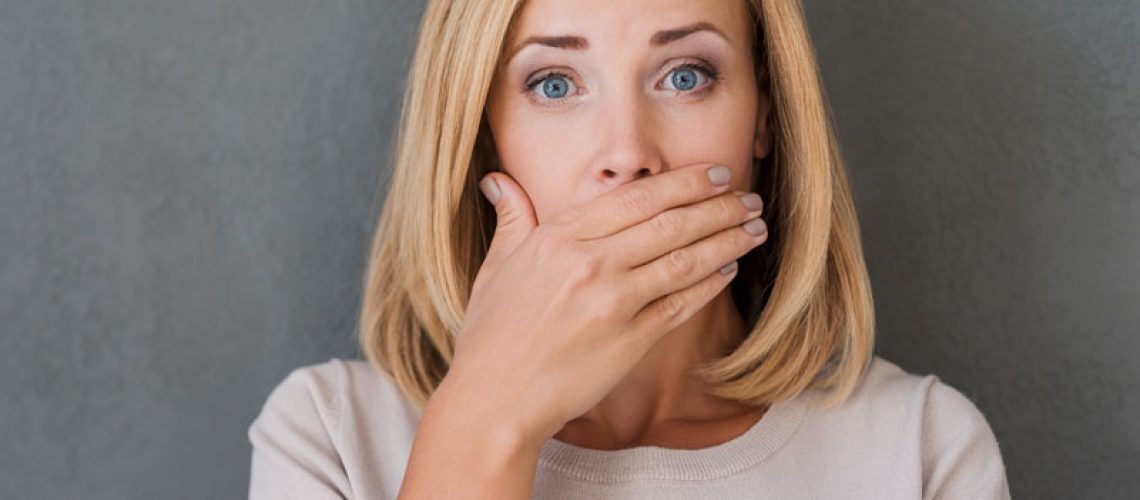 Dental Implant Patient Covering Her Mouth